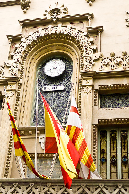 Spanish and Catalan flags wave from a building in Barcelona, Spain.
