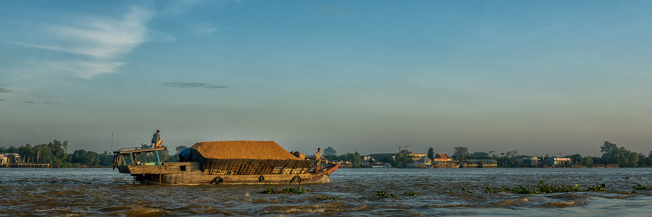 A boat in the morning sunshine on the Cổ Chiên River near Vinh Long in the Mekong Delta. A boat in the morning sunshine on the Cổ Chiên River.