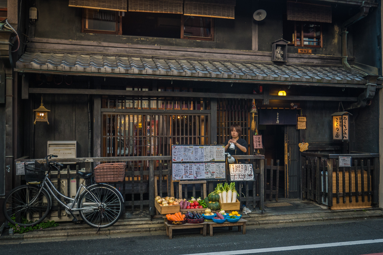 After exploring the Nishiki Market in Kyoto, dusk was settling over the city so I set out in search of vegetarian food. Finding veg-friendly restaurants was a challenge throughout Japan, so I wandered the narrow back alleys, zigzagging through the light crowds, dodging bicyclists whizzing past me. I spotted this woman setting up for the pending dinner crowds. I loved the look of the old preserved wood and that colorful pile of veggies. I circled back an hour later when they were open for dinner and feasted on yudofu, a boiled, savory tofu dish popular in the region. old building in Kyoto