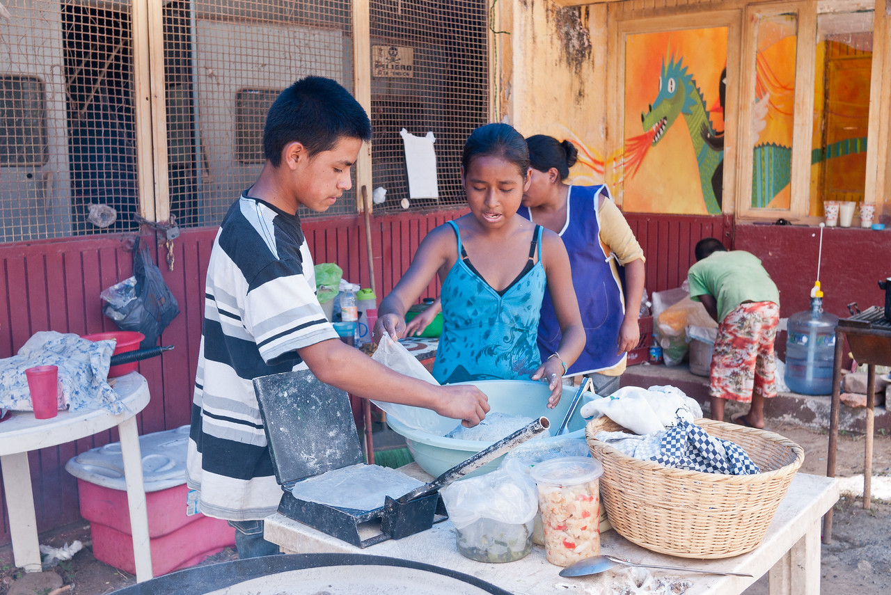 Learning how to make blue corn tortillas in from a street food vendor in Mexico.