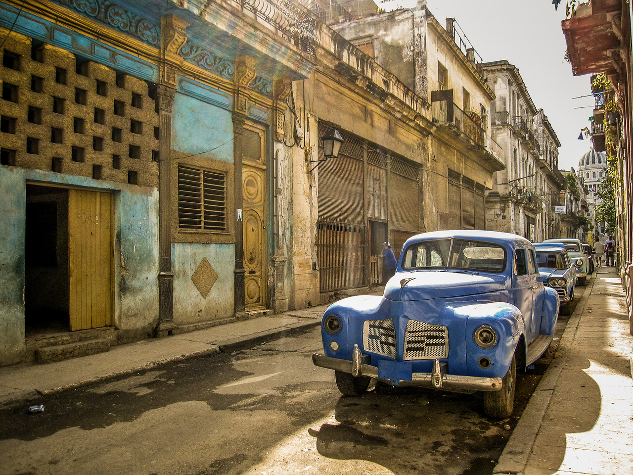 streets of havana cuba and an old blue car glinting in the sun