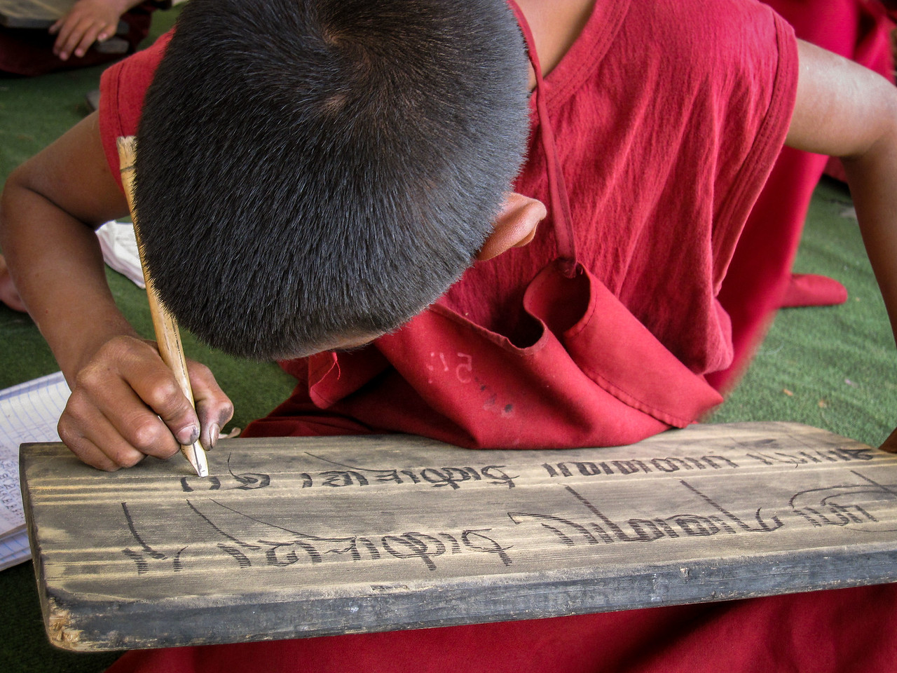 monk in nepal writing Tibetan script.