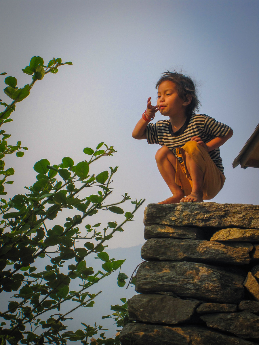 A local girl blows a ladybug from the leaf during a hike in the Himalayas on the Poon Hill trek. hiking himalayas, nepal