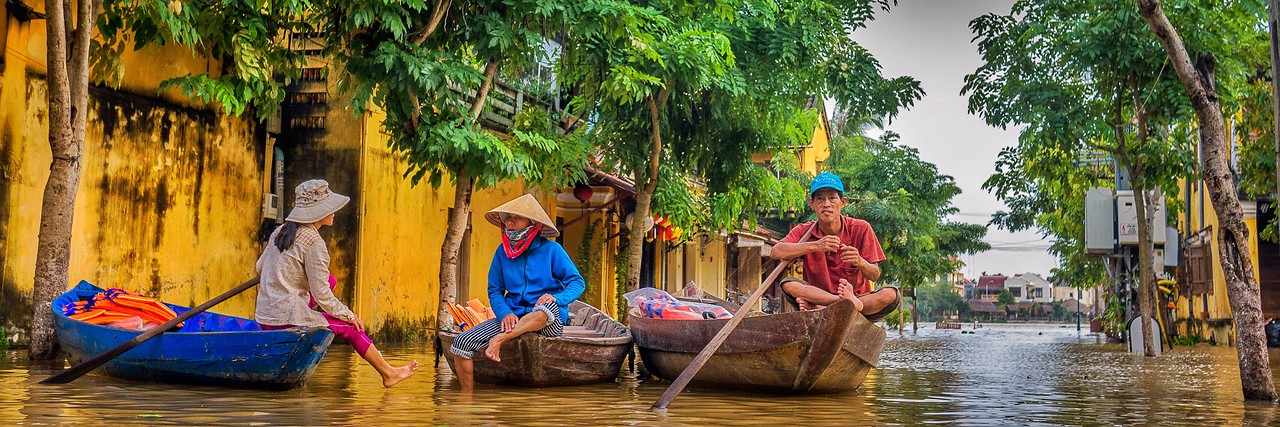Local boats ask tourists if they want to explore Ancient Town by boat during the flooding. Flooding in Hoi An, Vietnam.
