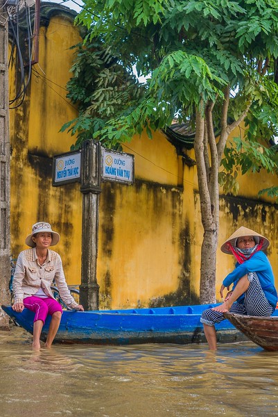 Two women assess the situation after historic flooding while traveling in Hoi An, Vietnam. responsible travel guide Hoi An, Vietnam