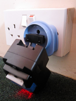 A very wonky way to charge my camera battery - capped off with some tape!